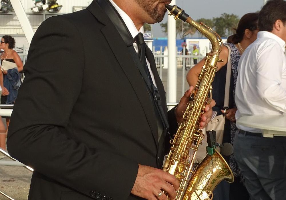 Puesta de sol saxofonista con copa de Cava o refresco. Verano 2024
